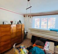 Szoba egy családi házban fa bútorokkal, csillárral és ablakkal, kilátással.