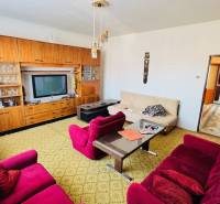 Nappali egy családi házban retro bútorokkal és színes fotelekkel.