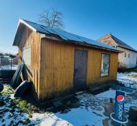 A partizánskei Nagybélben, egy ház mögött egy faház áll a havas udvaron.