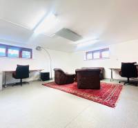 Otthoni iroda szőnyegdekorációval és bőrfotelekkel egy családi házban.