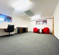 Az irodának a családi házban van szőnyege, íróasztala és piros székei.