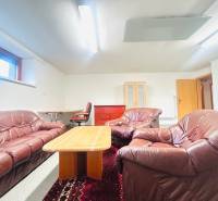 Bőr ülőgarnitúra dohányzóasztallal, szőnyeggel és dolgozósarokkal a családi házban.