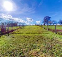 Napos telket Lieskovecben családi ház számára kerítéssel és fákkal egyenletes területen.