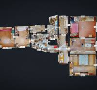 Családi ház alaprajza több szobával, konyhával és fürdőszobákkal, fa dekorációjú padlóval.