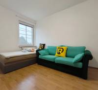 Szoba kanapéval és ággyal, fa dekoros padlóval, családi ház.