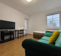 Nappali egy családi házban kanapéval, televízióval, asztallal és fa dekorációjú padlóval.