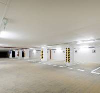 Földalatti parkoló világos világítással és kijelölt parkolóhelyekkel.