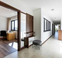 Világos folyosó dolgozószobával és fa dekoros padlóval egy háromszobás lakásban.