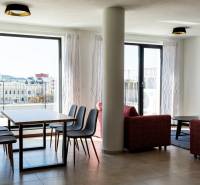 A háromszobás lakás nappalija étkezőasztallal és kilátással a városra.