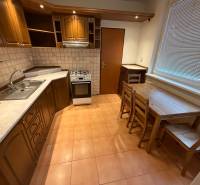 3 szobás lakás konyhája fa dekorú szekrényekkel és étkező ülőgarnitúrával.