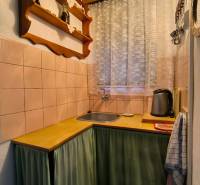 Konyha fahatású dekorral, polccal és függönnyel az ablaknál.