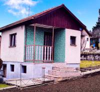 Ház Partizánske-ban parkosított kerttel, zöld homlokzattal és teraszra vezető lépcsővel.