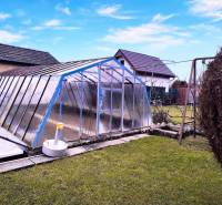 Kert Partizánske-ban, föld feletti medencével, amelyet szerkezet fed le, hinta, zöld gyep.