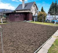 Kert házzal Partizánske városában, előkészített ágyás, környező zöldterület és faház.