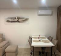 Ebédlő egy 3 szobás lakásban, fa dekor padlóval, asztallal és székekkel.