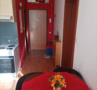 1 szobás lakás élénk piros falakkal és fa dekorációjú padlóval.