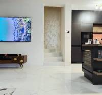 Nappali családi házban kandallóval és konyhaszigettel, fa dekorációjú padlóval.