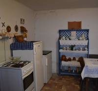 Konyha családi házban hagyományos bútorokkal és dekorációkkal, fa dekoros padlóval.