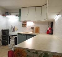 Konyha egy családi házban fehér téglafalakkal és konyhai készülékekkel.