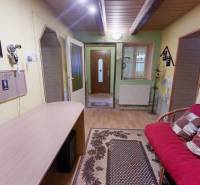 Családi ház belső tere fa dekorációjú padlóval, kényelmes kanapéval és dekorációkkal.