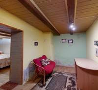 Szoba egy családi házban, fa dekoros padlóval, kanapéval és kis asztallal.