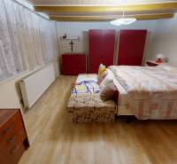 Hálószoba családi házban ággyal, gardróbszekrényekkel és fa dekorációjú padlóval.