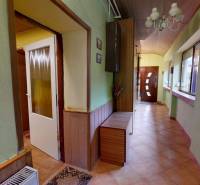 Folyosó csempével, dekorációkkal és függőlámpával egy családi házban.