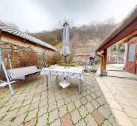 A Hlavná utcai családi ház gangja Hronský Beňadikban hintával és asztallal.