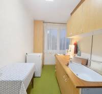 Konyha egy 3 szobás lakásban egyszerű berendezéssel, fa dekoros padlóval.