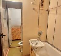 Fürdőszoba egy háromszobás lakásban káddal és mosdóval.