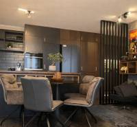 Konyha egy kétszobás lakásban sötét szekrényekkel és dekoratív poszterekkel a falon.