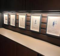 Keretbe foglalt képek egy kétszobás lakás fa polcos falán.