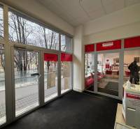 Üzlethelyiség belső tere utcára néző kilátással, üvegajtón keresztül.