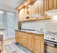 Konyha egy 4 szobás lakásban, fa dekor padlóval és étkező sarokkal.