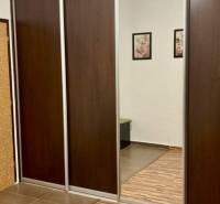 Tolóajtós és tükrös szekrény egy háromszobás lakásban, fa dekoros padlóval.