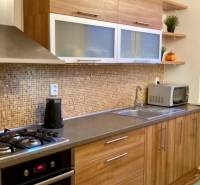 Konyha fa dekorációval és beépített készülékekkel egy háromszobás lakásban.