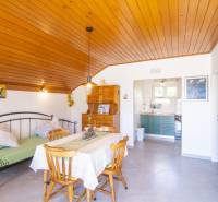 Nyaraló apartman fa dekor padlóval, étkezőasztallal és konyhával.