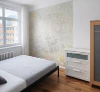 Hálószoba egy kétszobás lakásban fa dekorációval és eredeti falakkal.