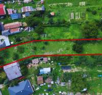 Légi felvétel egy lakóhelyre alkalmas telekről Lastomírban, amelyet zöldterület és házak vesznek körül.