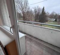 Erkély egy 2 szobás lakásban kilátással a környékre, csempe, fák.