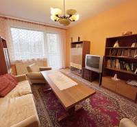 Nappali egy kétszobás lakásban, fa dekor padlóval és retro bútorokkal.