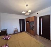 Hálószoba egy kétszobás lakásban ággyal, szekrénnyel és fa dekorációjú padlóval.