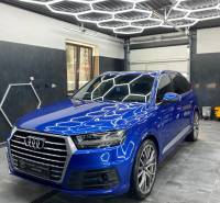 Audi SUV kereskedelmi helyiségekben csempézett padlóval és geometrikus mennyezeti világítással.