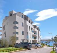 Rekreációs apartman épülete Pag városában, közel a tengerhez. Parkoló az épület mellett.