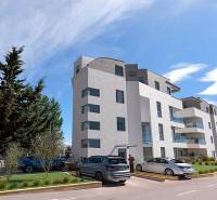 Nyaraló apartman Pag városában modern épülettel és parkolóval.