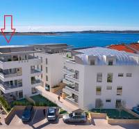 Kilátás egy tengeröbölre Pag városában, modern építészet a part mentén.