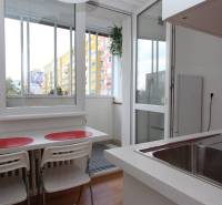 Konyha egy egyszobás lakásban kilátással és erkéllyel, fa dekor padlóval.