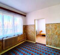 Családi ház belső tere járólappal, radiátorral és függönyös ablakkal.