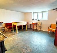 Családi ház pincéje bútorokkal és ablakkal, betonpadló.