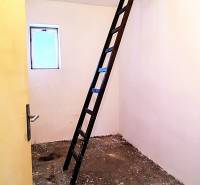 Padlás egy családi házban, létrával, amely a mennyezeti nyíláshoz vezet.